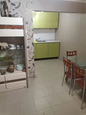 a kitchen with green cabinets and a table and chairs at Вилла Яна in Sveti Vlas