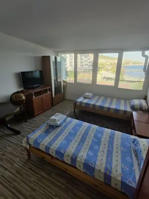 a hotel room with two beds and a television at Вилла Яна in Sveti Vlas