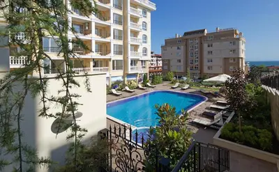 an apartment with a swimming pool in a building at Уютно студио до морето - апартаменти 25 и 26, топ локация - Cozy Studio by the Sea - Apartments 25 and 26 Top Location in Sveti Vlas