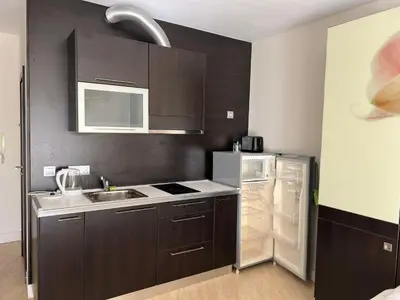 a kitchen with brown cabinets and a refrigerator at Midia Grand Resort Aheloy in Aheloy