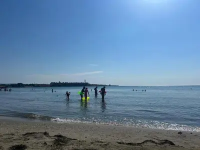 a group of people standing in the water at the beach at Midia Grand Resort Aheloy in Aheloy