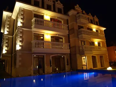 a building with a swimming pool in front of it at night at Guest House Aristokrat in Obzor