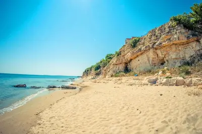 a sandy beach next to the ocean on a clear day at 1kk ve Sveti Vlas in Nesebar