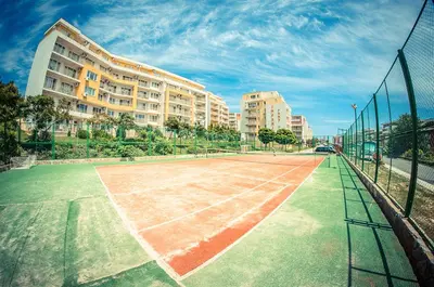 a tennis court in front of a building at 1kk ve Sveti Vlas in Nesebar