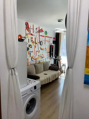 a living room with a washing machine in a room at Sunny view South studio Мир Авангарда in Sunny Beach