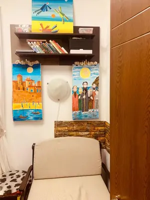 a room with a chair and paintings on the wall at Студия Мир Авангарда in Sunny Beach