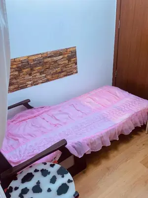 a room with a bed with a pink sheet on it at Студия Мир Авангарда in Sunny Beach