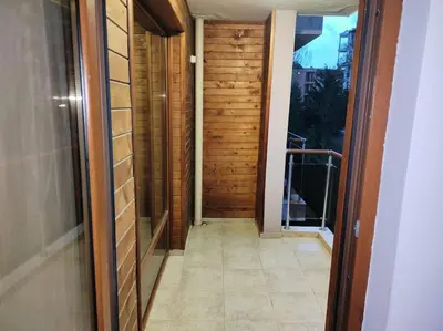 a hallway with a wooden door and a balcony at Просторная квартира в популярном комплексе in Sunny Beach