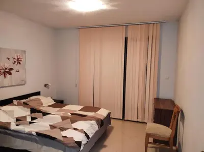 a bedroom with a large bed and a chair at Просторная квартира в популярном комплексе in Sunny Beach