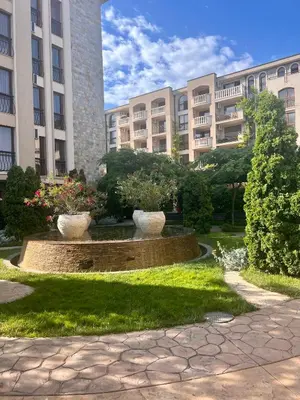 a park in front of a building with two vases at Luxury Apartment in Cascadas Family Resort Sunny Beach in Sunny Beach