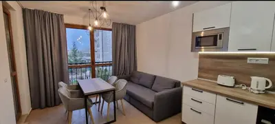 a kitchen and living room with a couch and a table at Luxury Apartment in Cascadas Family Resort Sunny Beach in Sunny Beach