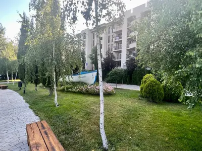 a park with a bench and a boat in the grass at Luxury Apartment in Cascadas Family Resort Sunny Beach in Sunny Beach