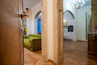 a door to a living room with a green couch at Elite place Suite in Varna City