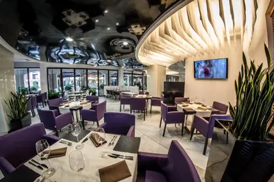 a dining room with tables and purple chairs at Premier Fort Cuisine - Full Board in Sunny Beach