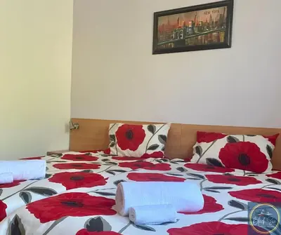 a bed with red and white flowers on it at 2 Bed Apt at Watermill Complex in Sveti Vlas