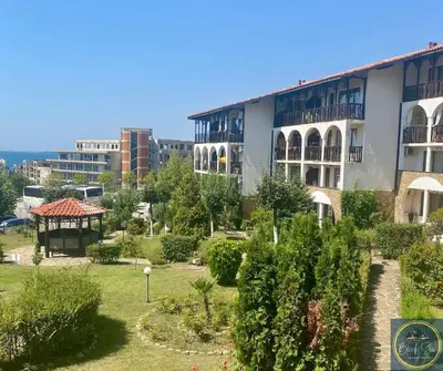 a large building with a garden in front of it at 2 Bed Apt at Watermill Complex in Sveti Vlas