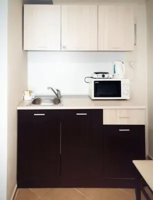 a kitchen with a sink and a microwave at Апартаменты Мисаря in Sozopol