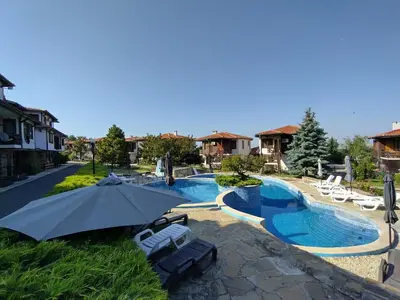 a swimming pool with an umbrella and lounge chairs at Bay View Villas apartment NONA 1C - Kosharitsa in Kosharitsa