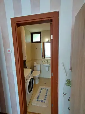 a bathroom with a toilet and a washing machine at Bay View Villas apartment NONA 1C - Kosharitsa in Kosharitsa