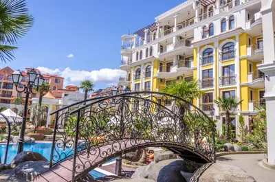 a bridge over a pool in a city with buildings at Harmony Suites - Monte Carlo in Sunny Beach