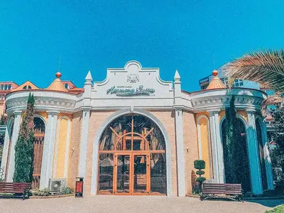 a building with a large door and a palm tree at Urlaub in Harmony in Sunny Beach