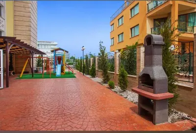a brick walkway with a playground next to a building at Sweet Homes 2 Apartments in Sunny Beach