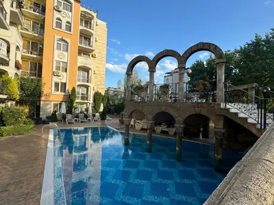 a swimming pool with a bridge and a building at Sweet Homes 2 Apartments in Sunny Beach