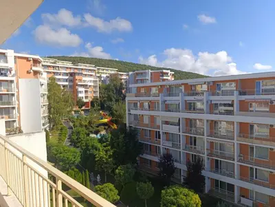 an apartment building with a hill in the background at Aria private apartments in Fort Noks Grand Resort - Saint Vlas in Elenite