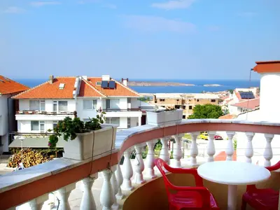 a balcony with a table and chairs and a view at Hotel Bobchev in Sozopol