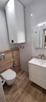 a white bathroom with a toilet and a sink at Kate`s Place in Burgas City