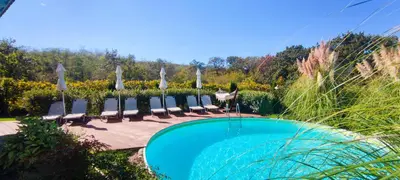 a swimming pool with lounge chairs and umbrellas at Casa Alegra in Bliznatsi