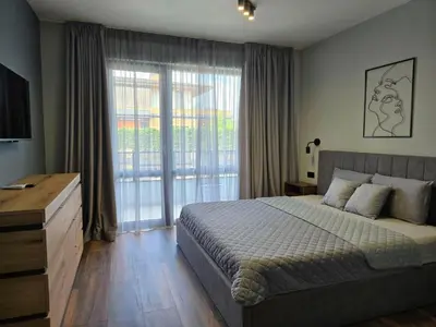 a bedroom with a bed and a large window at Villa Felicity, private pool with heating and salt water in Lozenets