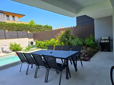 a patio with a table and chairs and a pool at Villa Felicity, private pool with heating and salt water in Lozenets