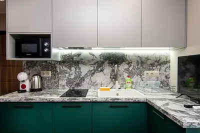 a kitchen with green cabinets and a white sink at Tiny studio in center of Varna in Varna City