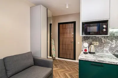 a living room with a couch and a kitchen at Tiny studio in center of Varna in Varna City