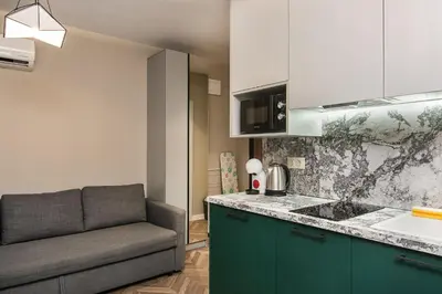 a kitchen with a couch and a sink and a counter at Tiny studio in center of Varna in Varna City