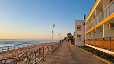 a walkway along the beach next to a building at SeaInn in Obzor