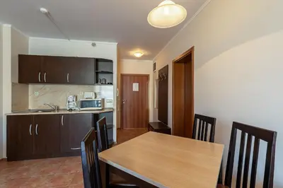 a kitchen and dining room with a wooden table and chairs at Midia Holiday Apartments in Aheloy