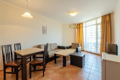 a living room with a table and a couch at Midia Holiday Apartments in Aheloy