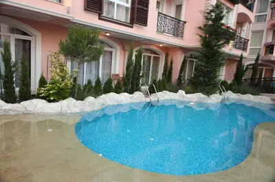a large blue swimming pool in front of a building at Menada Romance Marine Apartments in Sunny Beach