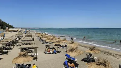 a beach with many umbrellas and people on the beach at Cosy apartment near the beach with terrace & sea view in Burgas City