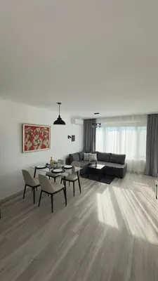 a living room with a couch and a table and chairs at Prestige Apartment 1 in Burgas City