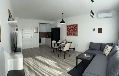 a living room and kitchen with a couch and a table at Prestige Apartment 1 in Burgas City