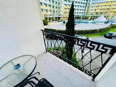 a glass table and chairs on a balcony with a street at VICTORIA RESIDENCE Two Bedroom Sunny Beach in Sunny Beach