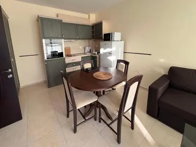 a kitchen and a table and chairs in a room at Sunset Apartment Pomorie in Pomorie