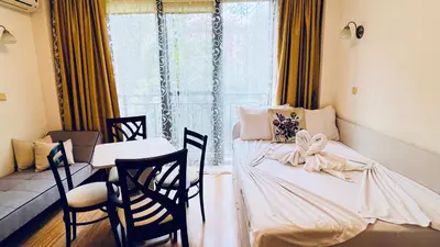 a room with two beds and a table and chairs at Amara В 10 Sunny Beach in Sunny Beach