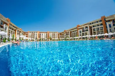 a large pool of blue water in a resort at Prestige Fort Beach - Menada Apartments in Sveti Vlas