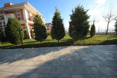 a driveway in front of a building with trees at Prestige Fort Beach - Menada Apartments in Sveti Vlas