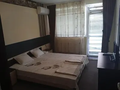 a bedroom with a bed and a window at Къща за гости in Primorsko