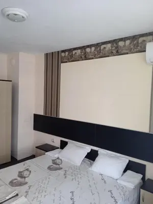 a bedroom with a bed with a black headboard at Къща за гости in Primorsko